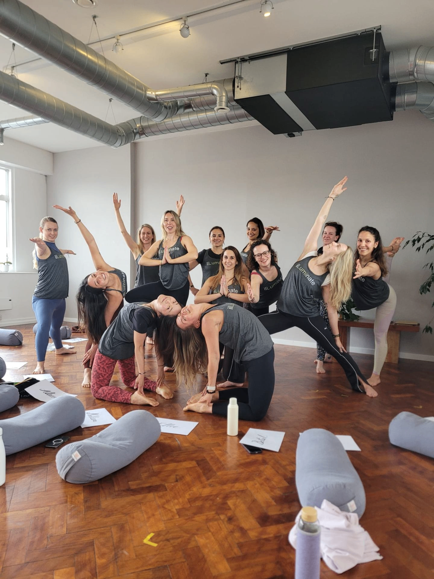 Alysa with her yoga teacher training cohort, mid-practice in the studio