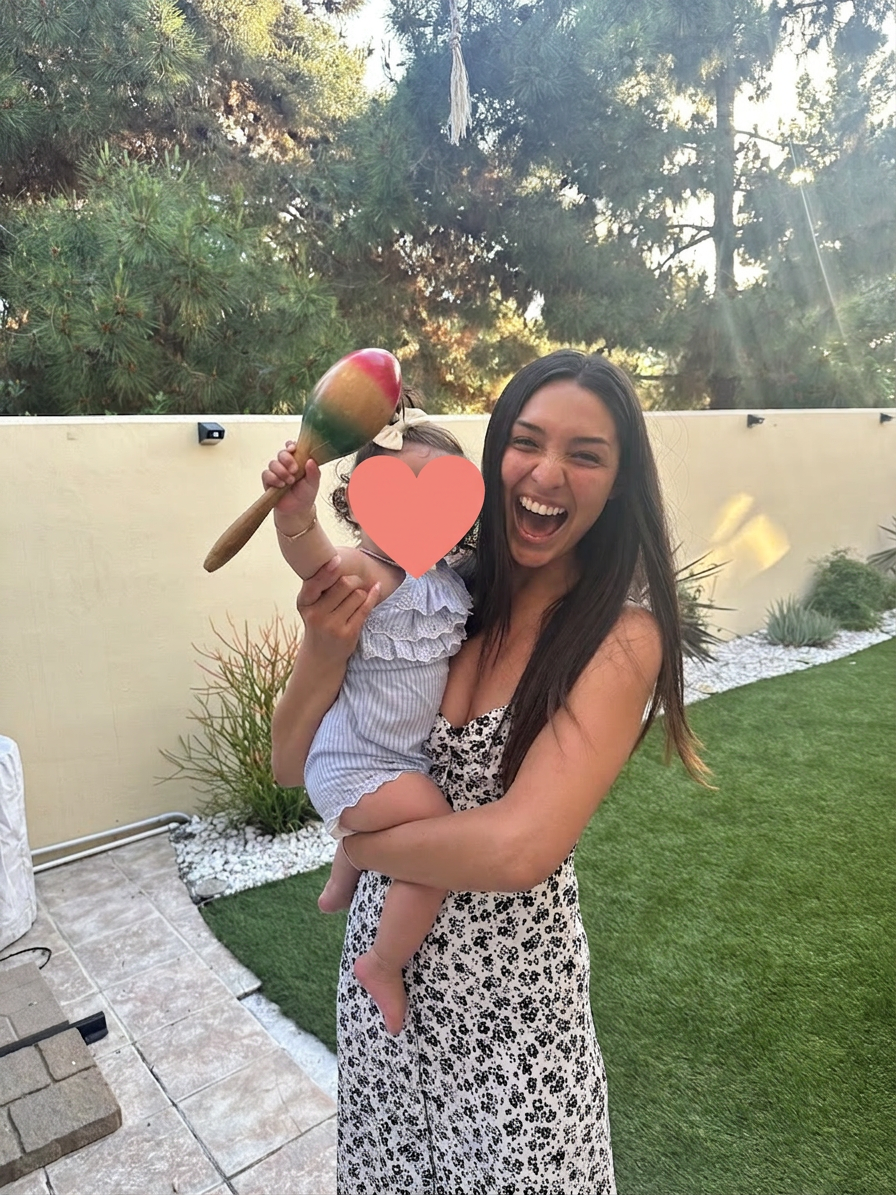 Alysa holding a small child outdoors at golden hour